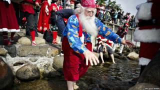 A Santa taking a footbath in Copenhagen during the World Santa Claus Congress