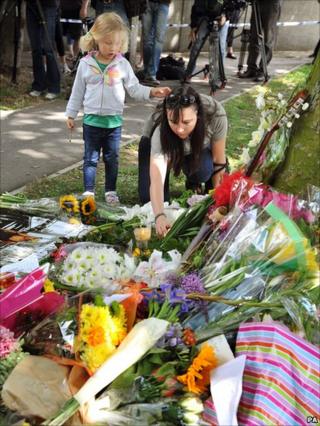 Mother and daughter lay flowers by Amy's House