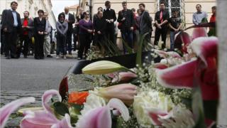 People stand in front of the Norwegian embassy in Prague 24, July 2011, to pay tribute to the victims of the two attacks in Norway