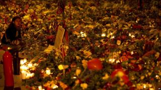 Someone looking at the sea of floral tributes outside Oslo cathedral