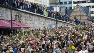 Crowds gather on the streets of the Norwegian capital Oslo to pay tribute to those who were killed in the bomb blast and shootings there