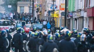 Riot police face a mob in Hackney, north London