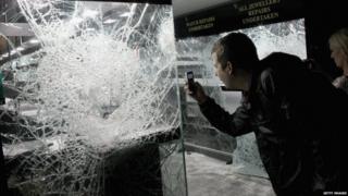 This man photographs a pawn shop that's been ransacked by looters in Clapham, south London