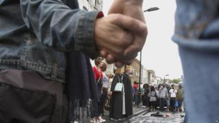 Volunteers in Hackney stand together in solidarity before they start help clear up their town.