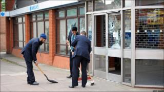Bank workers clean up broken glass