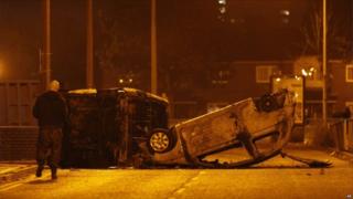 Burned cars are seen during trouble in Salford, near Manchester
