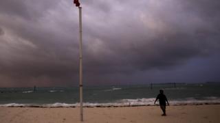 A boy walks on a beach in Nassau, in the Bahamas.