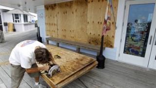 A man using a saw to cut a piece of plywood