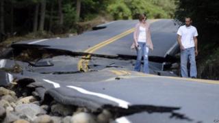 Jarrid Gonyea and his wife Michelle Gonyea are from Wilmington, New York. They check out storm damage - this road has been split in two.