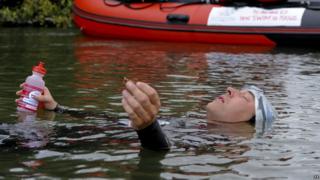 David Walliams rests for a drink and a snack on his Sport Relief swim of the River Thames