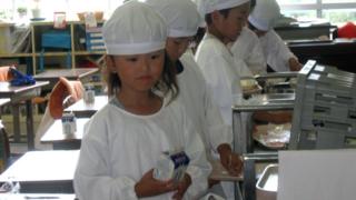 Young children returning their lunch trays Onagawa in Japan.