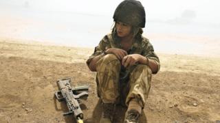 Cheryl Cole sitting down in the desert