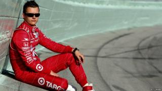 Dan Wheldon sitting on a racing track