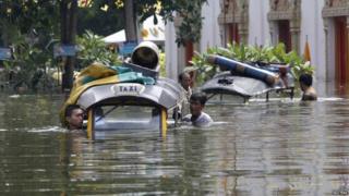 People pushing taxis through the water