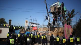Residents on scaffolding with Police stood below