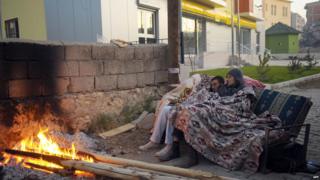 Two men sleeping outside by a fire