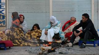 A family sleeping outside in the cold