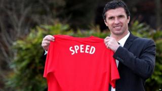 Gary Speed holds up a Wales shirt with his name on the back