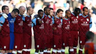 Aston Villa players stand for a moments silence in memory of Wales manger Gary Speed.