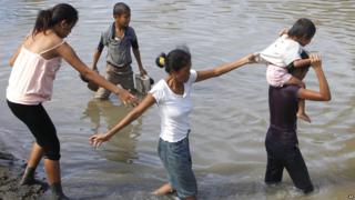 Survivors try to return to their homes