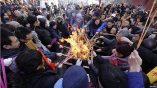 People burn incense to pray for good fortune on the first day of the Chinese Lunar New Year.
