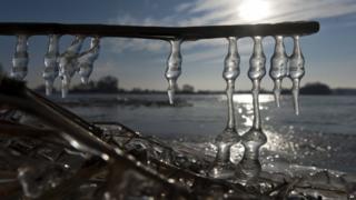 Icicles hang from a piece of wood