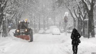 A snowplough clears snow off a road in the northern Italian
