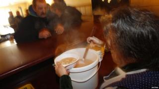 Homeless people given hot food at a soup kitchen in Poland