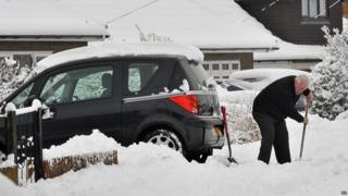 Man clearing snow in front of his car