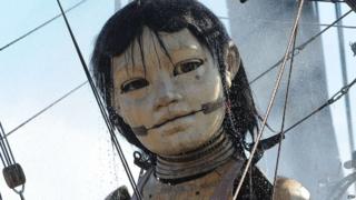 A giant puppet, part of a street theatre production entitled "Sea Odyssey", has a shower in the morning in Stanley Park.
