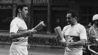 An athlete passes the Olympic flame to the next in the relay, ahead of the opening ceremony of the Mexico Olympics, 1968