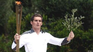 The first torch bearer, swimmer Spyros Gianniotis, runs with the Olympic flame on May 10, 2012 during the lighting ceremony at the ancient site of Olympia.