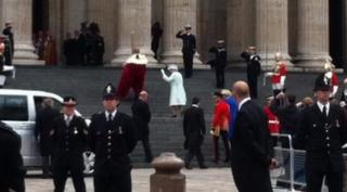 Queen waving on steps of cathedral