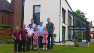 Joe in front of the 'eco home' with school kids, their teacher and the home's owner.