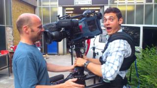 Marty the cameraman lets Joe have a go on his cool camera.