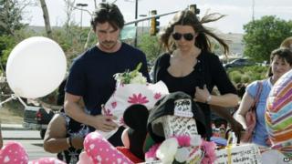 Christian Bale and his wife leaves flowers for a shooting victim