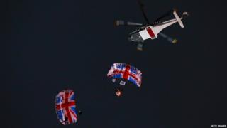 A stunt James Bond and Queen parachute into the stadium.