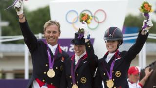 Riders Carl Hester, Laura Bechtolsheimer and Charlotte Dujardin getting gold medals