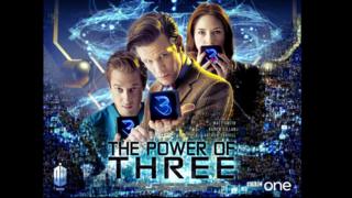 The Doctor and his companions hold cubes with the number 3 on them.