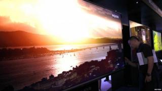 A member of the public looks at a giant television