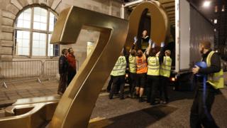 Workmen lift the iconic numbers 007 down from a lorry in preparation for the Royal premiere of Skyfall.