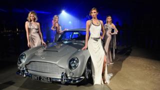 Models pose with the Aston Martin car from the film.