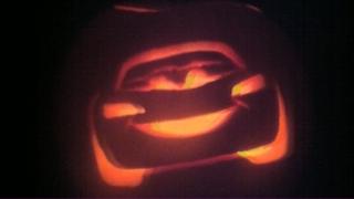 A pumpkin with a carving of Lightning McQueen from the movie Cars.