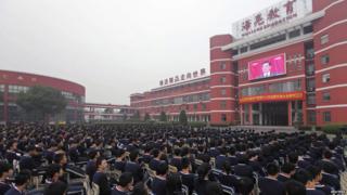 High school students in Zhuji watch a screen showing the Chinese president delivering a keynote report during the opening ceremony.