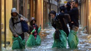People wade through he flooded streets in Venice after flooding.