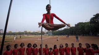 Girl performing a mallakhamb pose
