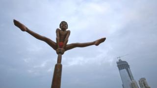 Boy performing a mallakhamb pose