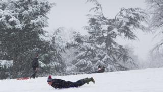 A man sledging in the snow in Wollaton Park, Nottingham