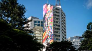 An ordinary concrete tower block in Sao Paulo with one side brightly painted.