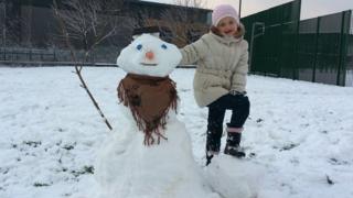 A girl with her snowman.